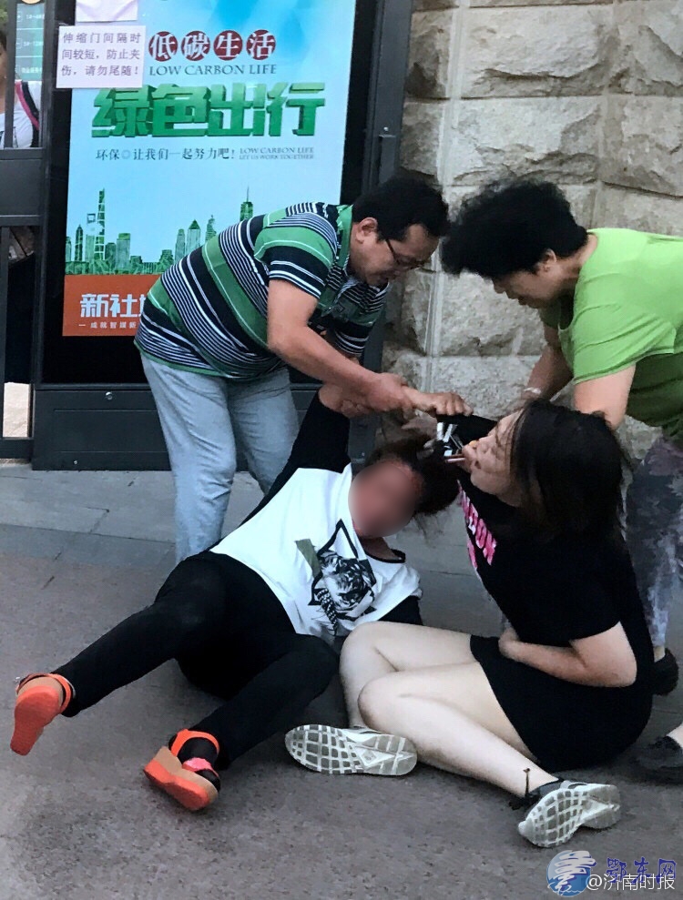 年轻女子(黑短裤)随即步行离开 山东两女子街头互殴 大妈真的厉害